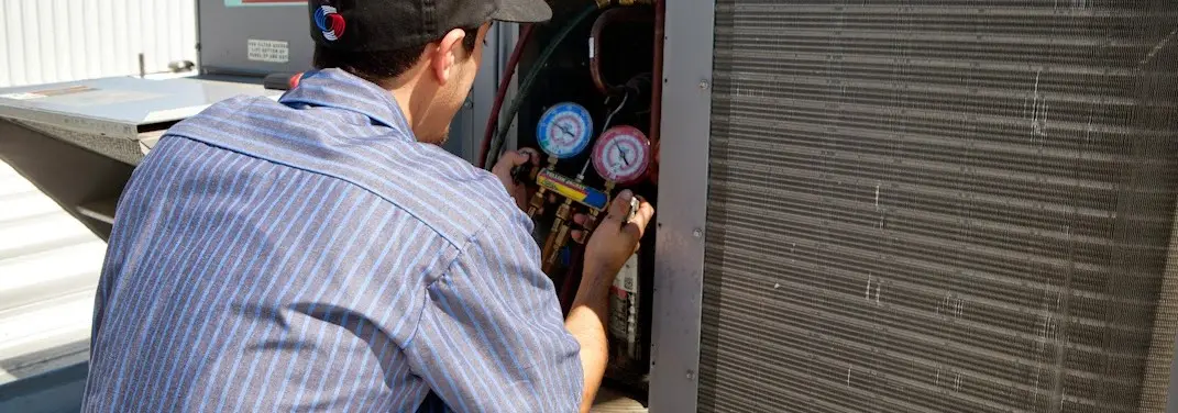 HVAC technician servicing a condenser unit in Dingman