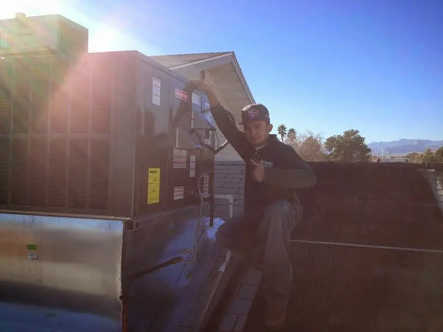HVAC technician performing Air Duct Repair on a rooftop unit in Dingman